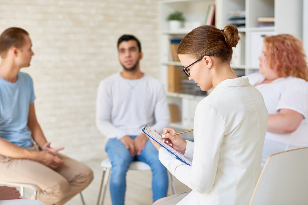 young female psychologist leading therapy session -