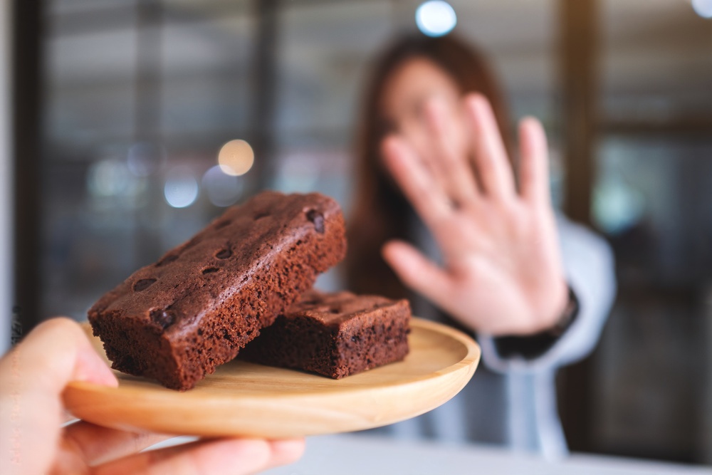 Frau lehnt Teller mit Brownies ab